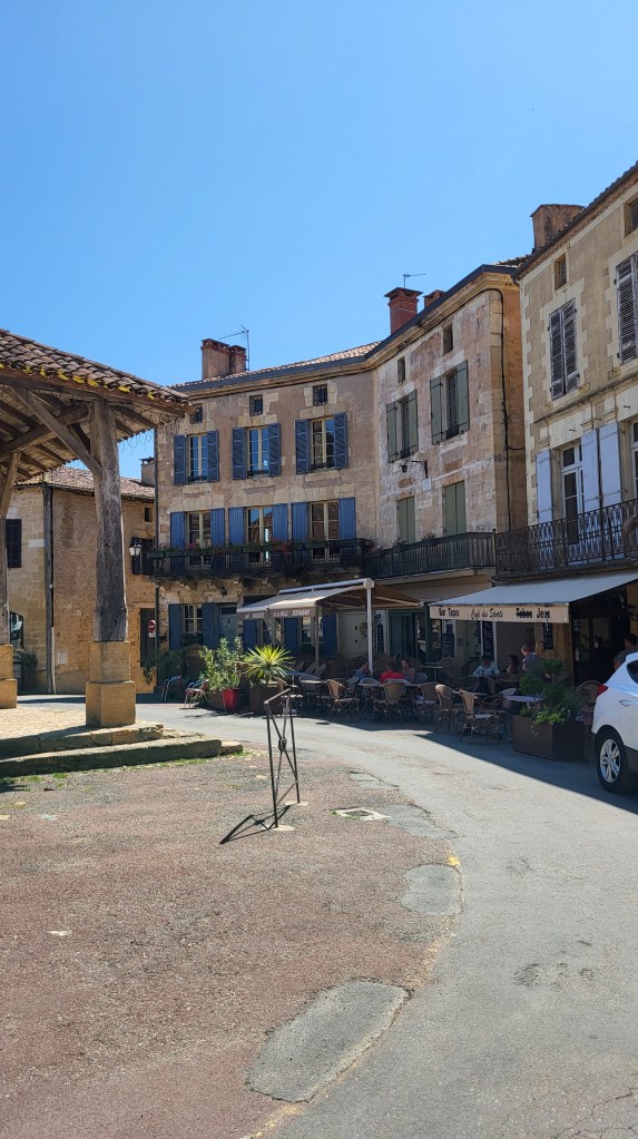 Weathered stone façade in Belvès with ivy and soft shadows in early summer